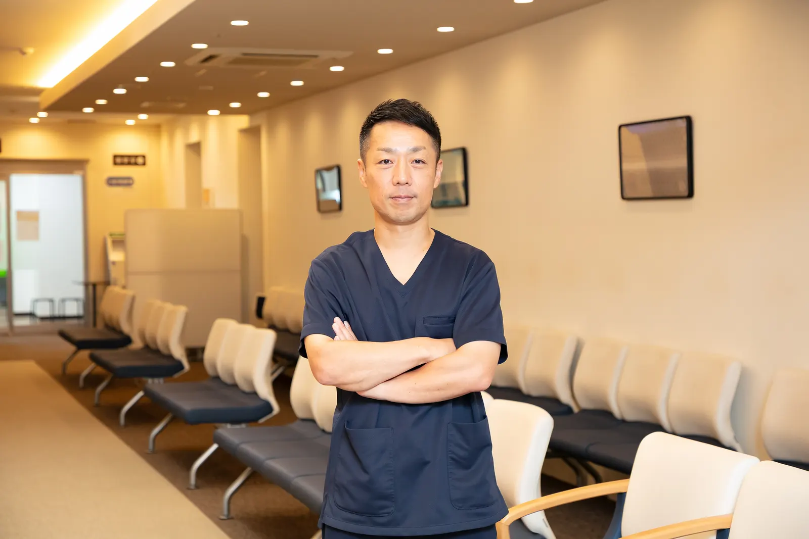 よしおかクリニックの待合室に立つ吉岡直樹医師